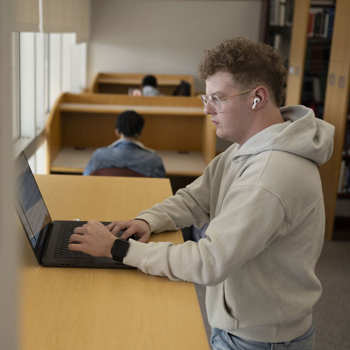 A student works from an adjustable desk in the music library