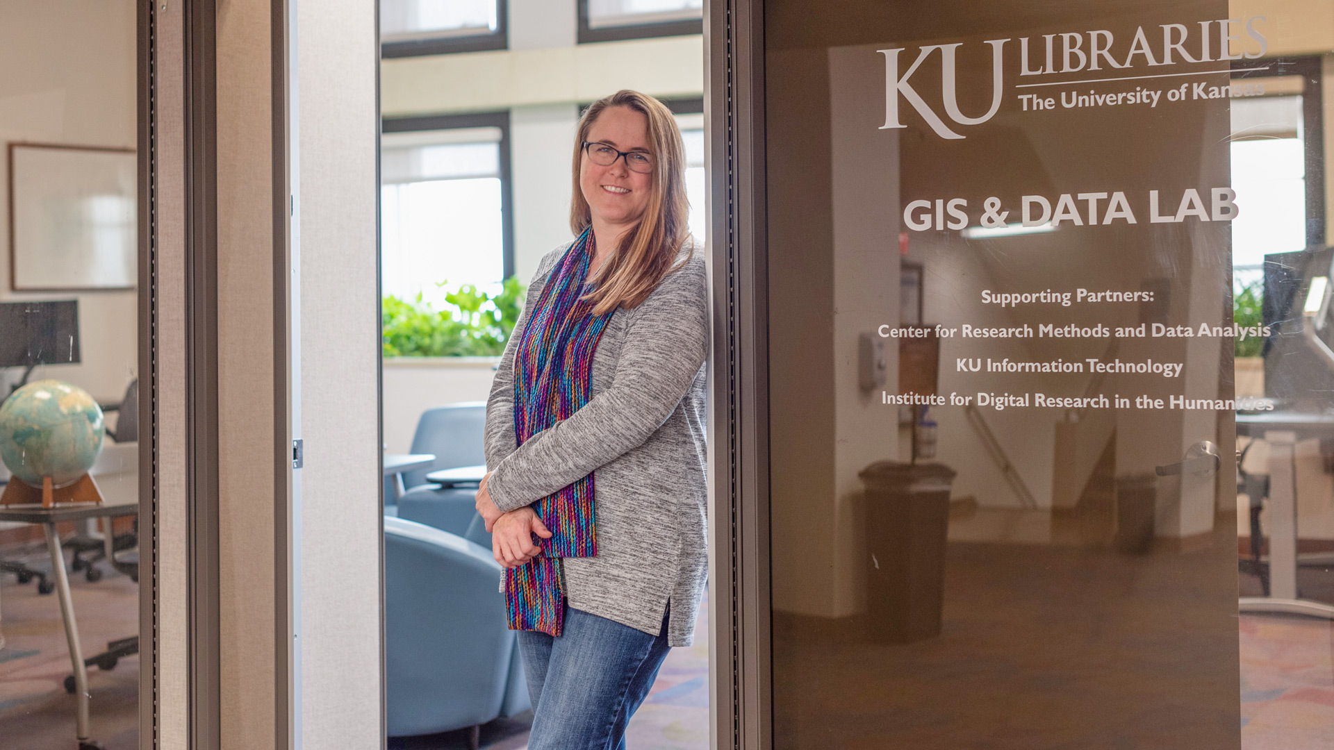 April Friedl poses in the doorway of the GIS Lab on Watson Library's Fourth Floor. 