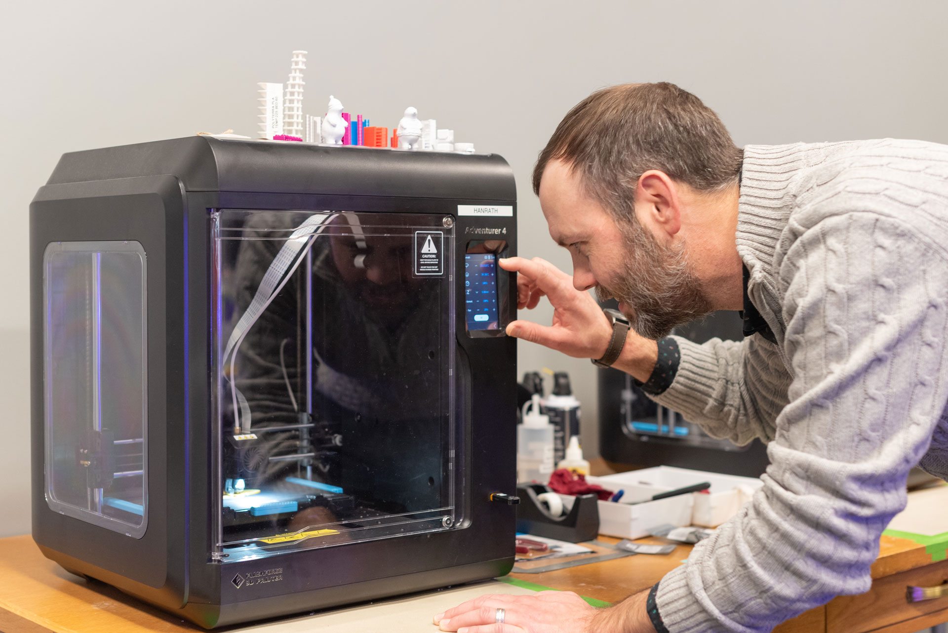 Matt Bristow checks on a 3D printer in the Makerspace.