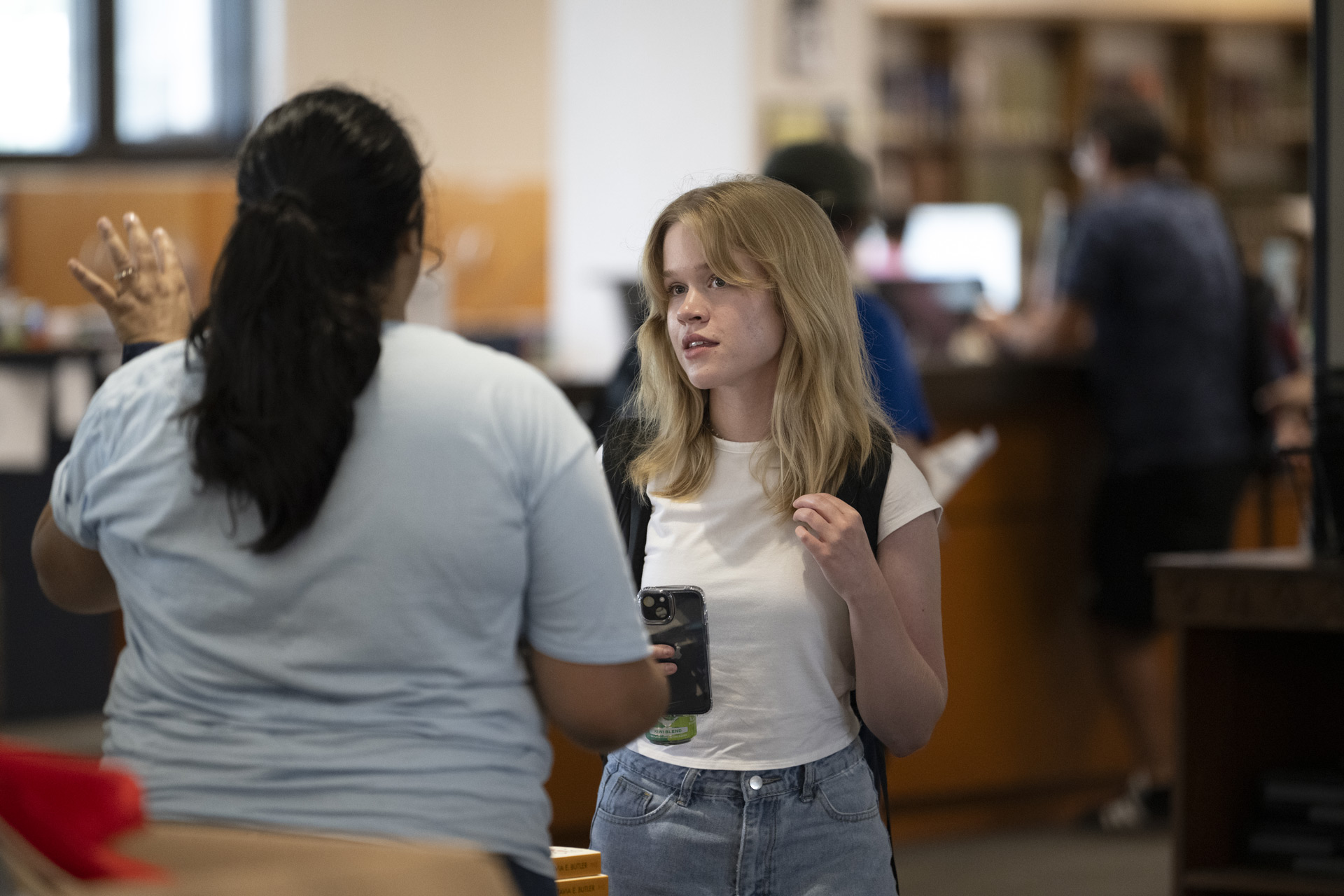 A student speaks with a librarian at a tabling event in Watson Library.