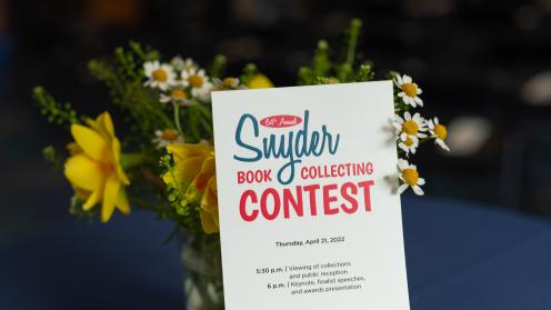 A Snyder Book Collecting Contest program propped up against a vase of flowers